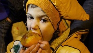 NIño sirio come fruta