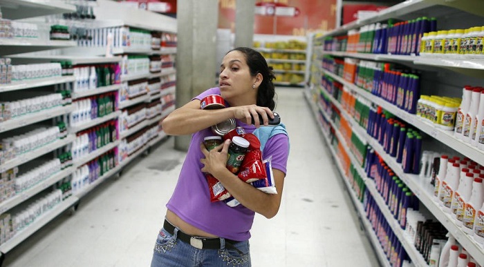 3 31 julio la comunidad corrió a abastecerse, esta mujer compró en el supermercado Bicentenario lo que alcanzó abrazar contra su cuerpo