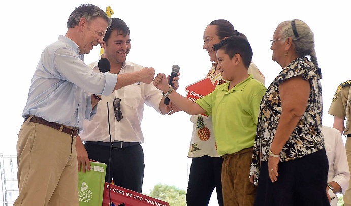 Un niño choca su mano en señal de amistad con el Presidente Juan Manuel Santos, durante la entrega de títulos y las llaves de 120 viviendas en la urbanización Mi Casa Ya-Ahorradores.