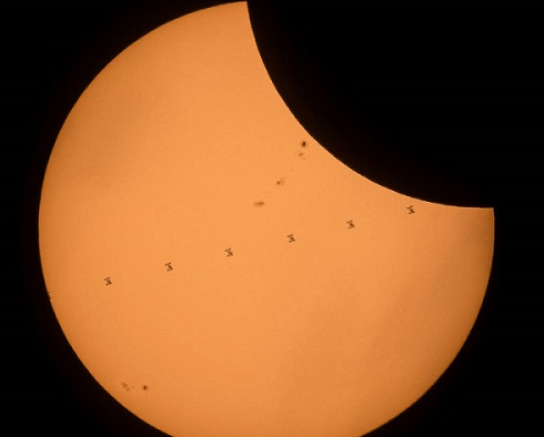 This composite image, made from seven frames, shows the International Space Station, with a crew of six onboard, as it transits the Sun at roughly five miles per second during a partial solar eclipse, Monday, Aug. 21, 2017 near Banner, Wyoming. Onboard as part of Expedition 52 are: NASA astronauts Peggy Whitson, Jack Fischer, and Randy Bresnik; Russian cosmonauts Fyodor Yurchikhin and Sergey Ryazanskiy; and ESA (European Space Agency) astronaut Paolo Nespoli. A total solar eclipse swept across a narrow portion of the contiguous United States from Lincoln Beach, Oregon to Charleston, South Carolina. A partial solar eclipse was visible across the entire North American continent along with parts of South America, Africa, and Europe.  Photo Credit: (NASA/Joel Kowsky)