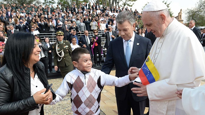 Un niño regala una pequeña bandera de Venezuela al Papa Francisco, al ingresar a la Casa de Nariño, acompañado por el Presidente Juan Manuel Santos.
