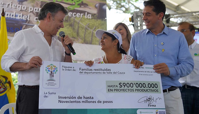 Un cheque para el apoyo a proyectos productivos de familias a las que se les restituyó las tierras entregó el Presidente Juan Manuel Santos, acompañado por el director de la Unidad de Restitución, Ricardo Sabogal.