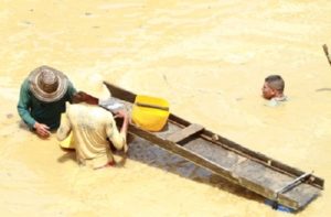 2 Hundidos hasta el cuello en las aguas envenenadas por las multinacionalesa buscan un gramo de oro em forma manual.